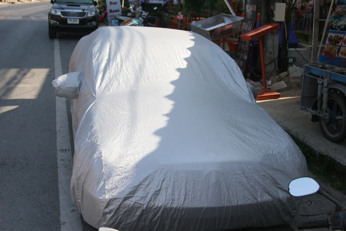 A car with a fitted protective cover parked outdoors