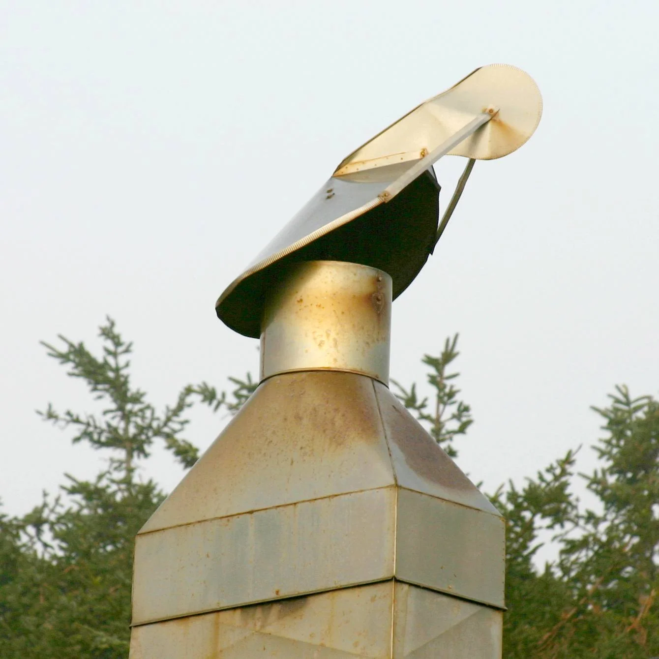 A wire-mesh chimney cowl of the type used to block birds, fitted on a residential chimney